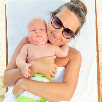Baby and mom are relaxing on sunbed