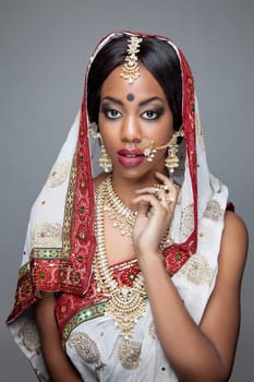 Young Indian woman dressed in traditional clothing with bridal makeup and jewelry