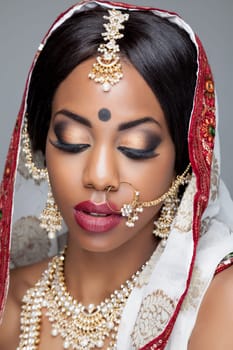 Young Indian woman dressed in traditional clothing with bridal makeup and jewelry