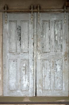 The photograph of an old sliding door of the ruins of a farm and storage building.
