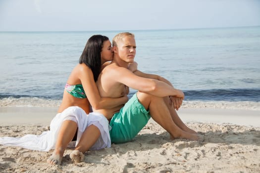 Young happy couple in love on the beach in summer holidays leisure rest recreation holiday sun