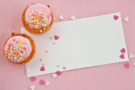 Small cupcake with colorful sugar sprinkles on pink