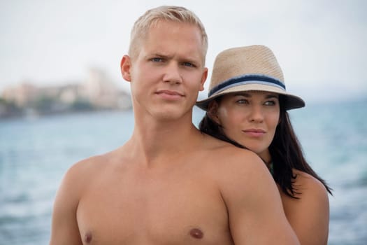 Laughing young couple in love on the beach in summer holiday leisure happy love