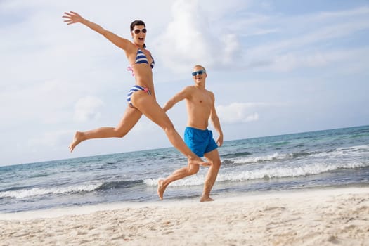 Young happy couple in love has fun on the beach in summer