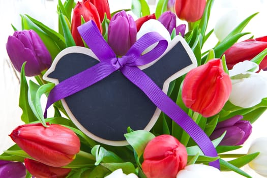 Fresh colorful tulips with small table in the shape of a bird