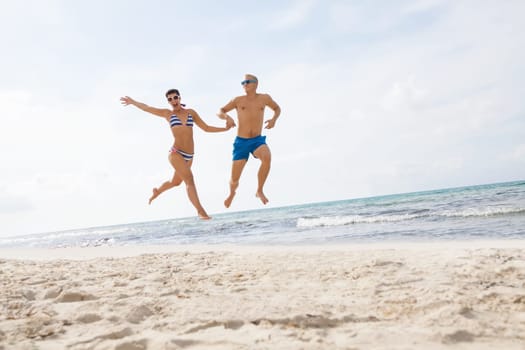 Young happy couple in love has fun on the beach in summer