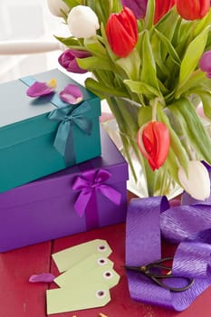 Colorful gift boxes with bow and fresh tulips