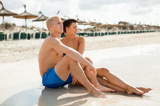 Young happy couple in love on the beach in summer holidays leisure rest recreation holiday sun