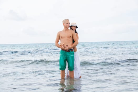 Laughing young couple in love on the beach in summer holiday leisure happy love