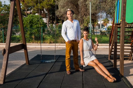Young elegant couple with fashionable clothes in summer outdoor leisure park