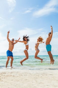 Group of laughing young people on the beach in summer holiday leisure lifestyle