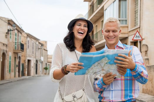Young attractive couple in summer in the city Tourists Travel Map Search for directions