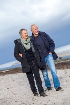 Older adult senior couple walking on the beach lifestyle happy healthy