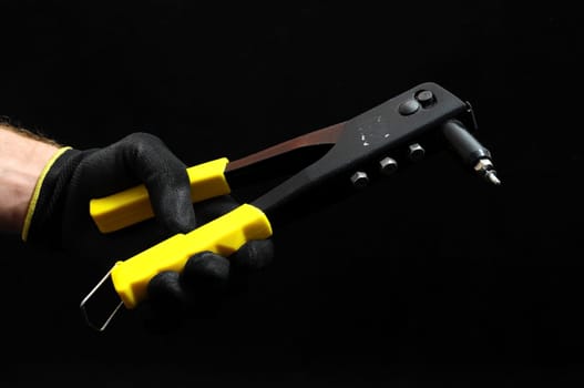 Rivets Pliers and Hand on a Black Background