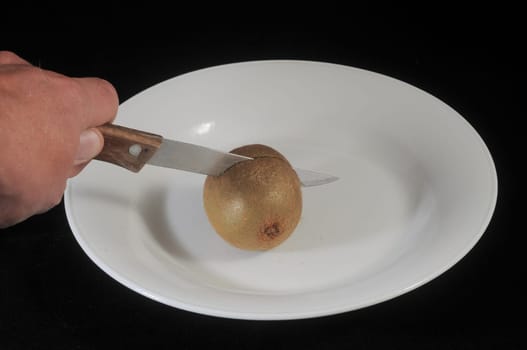 Cutting a Green and Brown Kiwi in Two Parts
