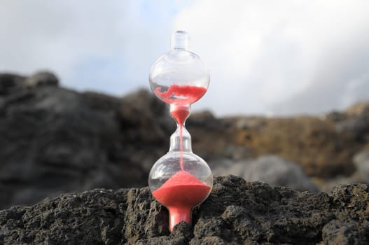 Time Concept - Hourglass Abandoned on the Volcanic Rocks