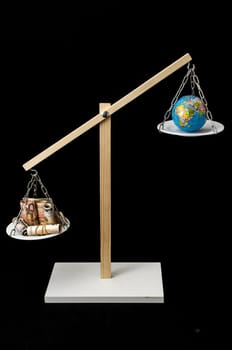 Globe Planet Earth and Money on a Two Pan Balance