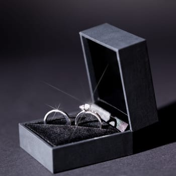 Engagement ring in a black box and a red rose macro detail Valentine's Day