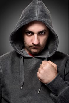 Young angry gangster with the hood on his head