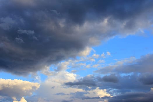dramatic cloudy mood in front of partly still blue sky - storm announces itself