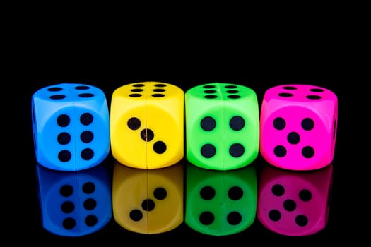 Four colorful dice, isolated on black background