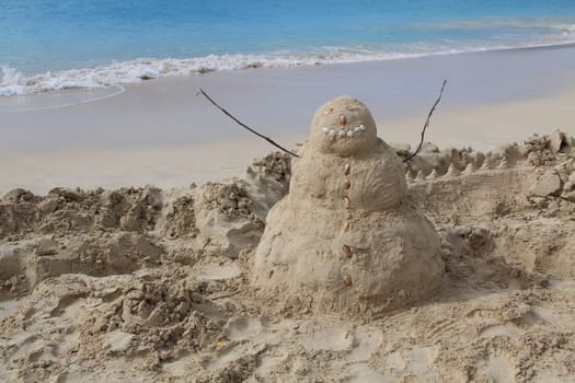 Sandman on a beach with the aqua blue waters of the Caribbean sea behind it in Antigua Barbuda Lesser Antilles, West Indies.