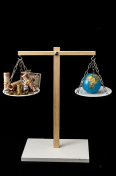 Globe Planet Earth and Money on a Two Pan Balance