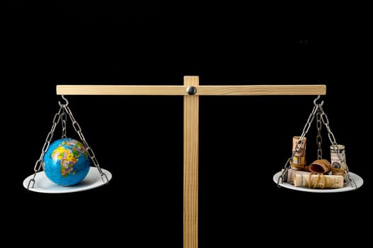 Globe Planet Earth and Money on a Two Pan Balance