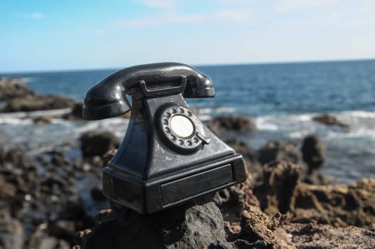 International Communications Vintage Telephone Toy on the Volcanic Rocks