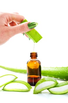 Woman's hand dropping a drop from a leaf of aloe vera in a bottle