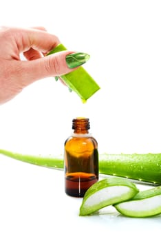 Woman's hand dropping a drop from a leaf of aloe vera in a bottle