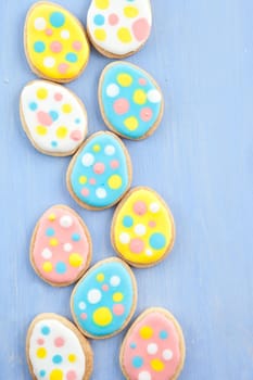 Colorful cookies for Easter on blue wooden background