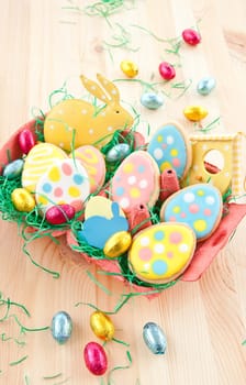 Colorful biscuits and chocolate eggs in Easter nest
