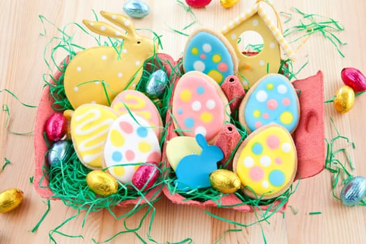 Colorful biscuits and chocolate eggs in Easter nest