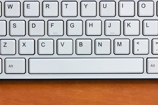 Silver computer keyboard on the wooden desk
