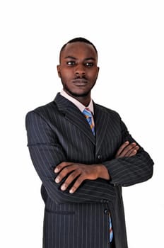 A young black business man standing in a suit and tie, with his arms.crossed for white background..