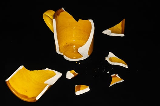 Broken Orange Coffee Cup on A Black Bacground