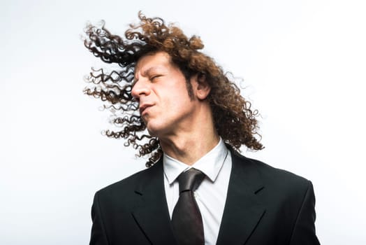 Curly haired businessman moving head with hair in the air
