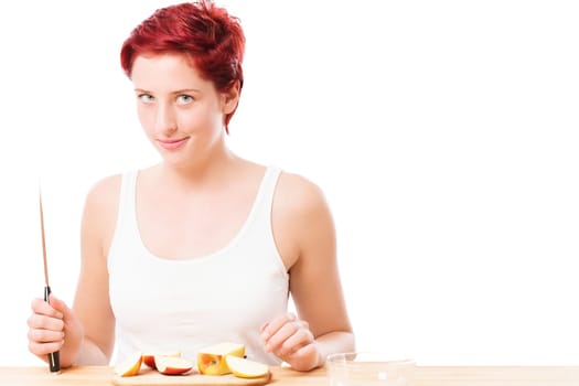 Cheeky young woman with knife has cut an apple against a white background