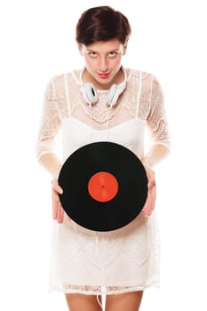Young Veschmitze woman with headphones holds record in front of a white background