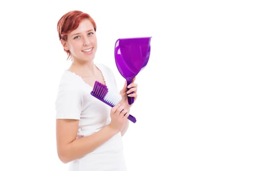 Happy young woman with broom and shovel against a white background