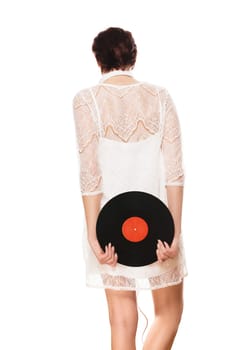Young woman in white dress from behind holds record in the back against a white background