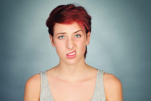 Young uncomprehending woman raises eyebrow and lip