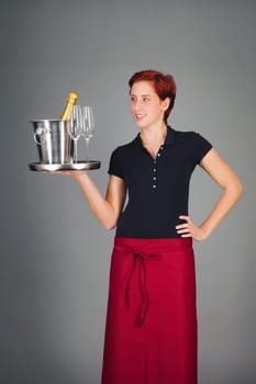 Laughing female waitress serves champagne on a tablet