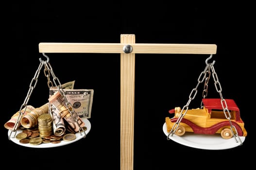 Money and Toy Wooden Car on a Two Pan Balance