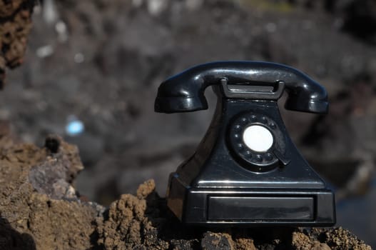 International Communications Vintage Telephone Toy on the Volcanic Rocks
