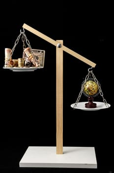 Globe Planet Earth and Money on a Two Pan Balance