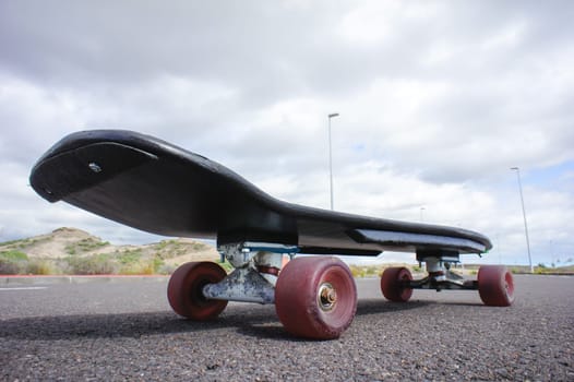 Vintage Style Longboard Black Skateboard on an Empty Asphalt Desert Road