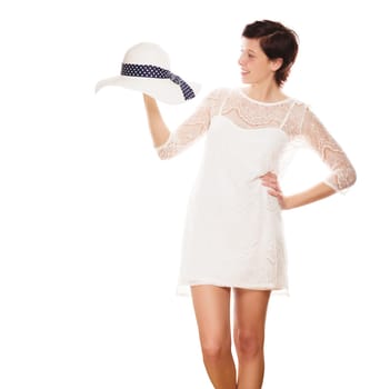 Young laughing woman holds sun hat in hand against a white background