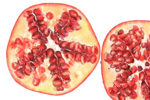Ripe,halved pomegranate (Punica granatum) exposed against a white background